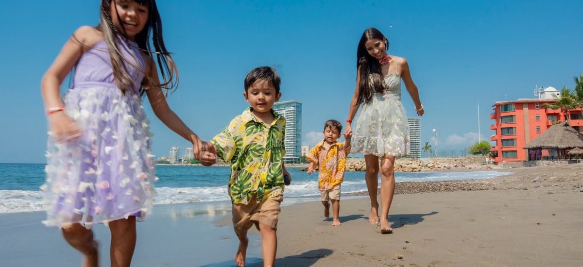 Cheerful family playing and running on a sunny beach, enjoying a vacation day together.